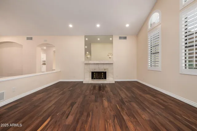 a view of empty room with wooden floor and fireplace