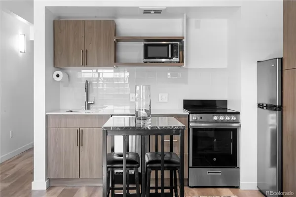 a kitchen with stainless steel appliances a stove a microwave and sink