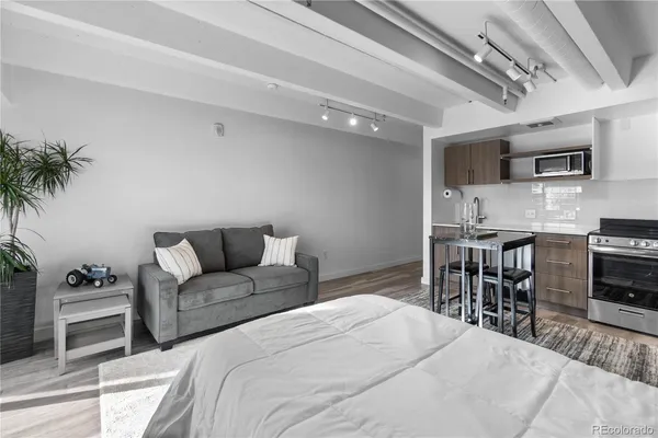 a bedroom with a large bed a table and chair with the potted plants