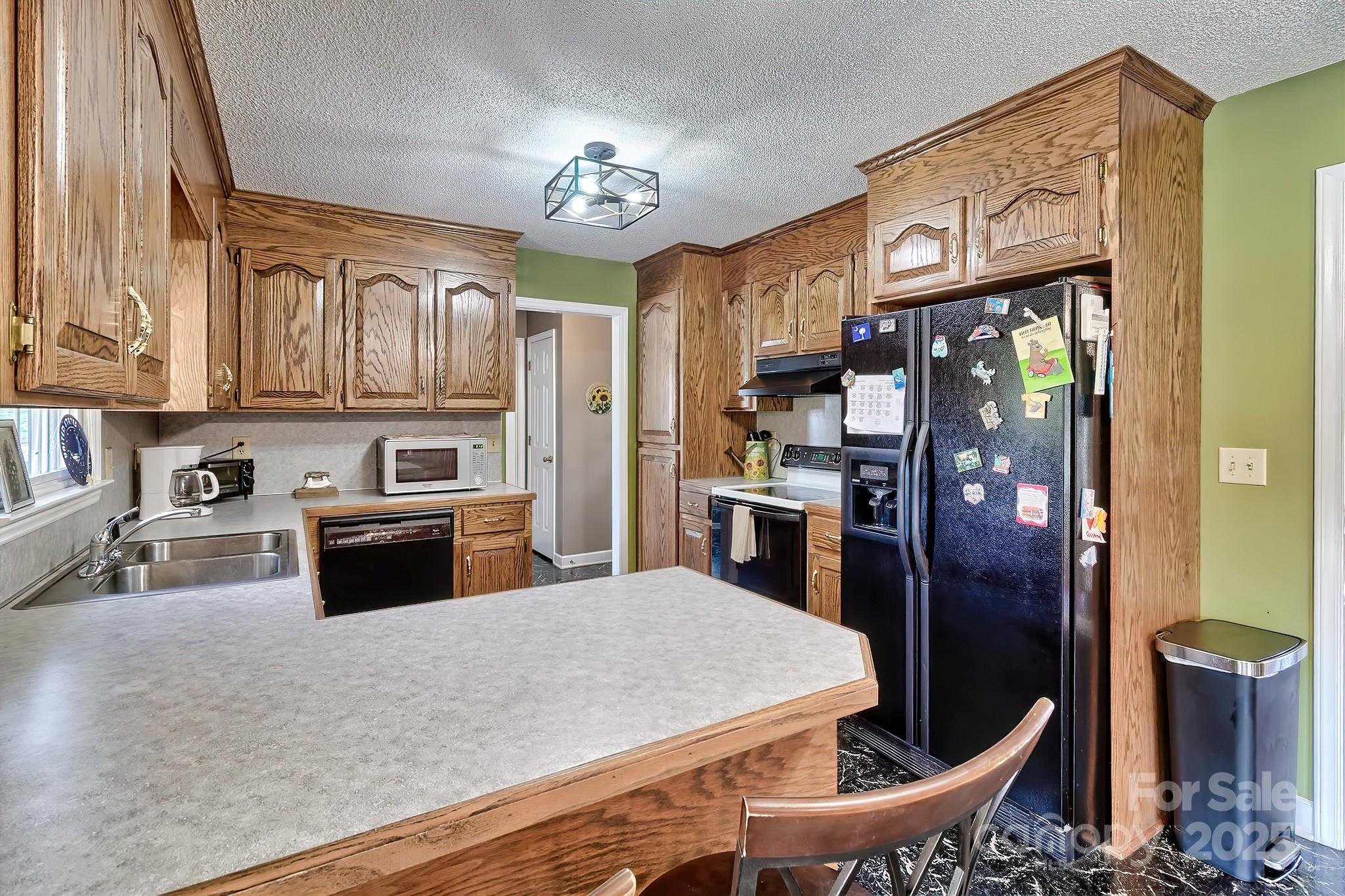 176 Griffin Road Pageland, SC 29728 - Photo 27 of 46 a kitchen with stainless steel appliances granite countertop a refrigerator a stove top oven a sink dishwasher and cabinets with wooden floor