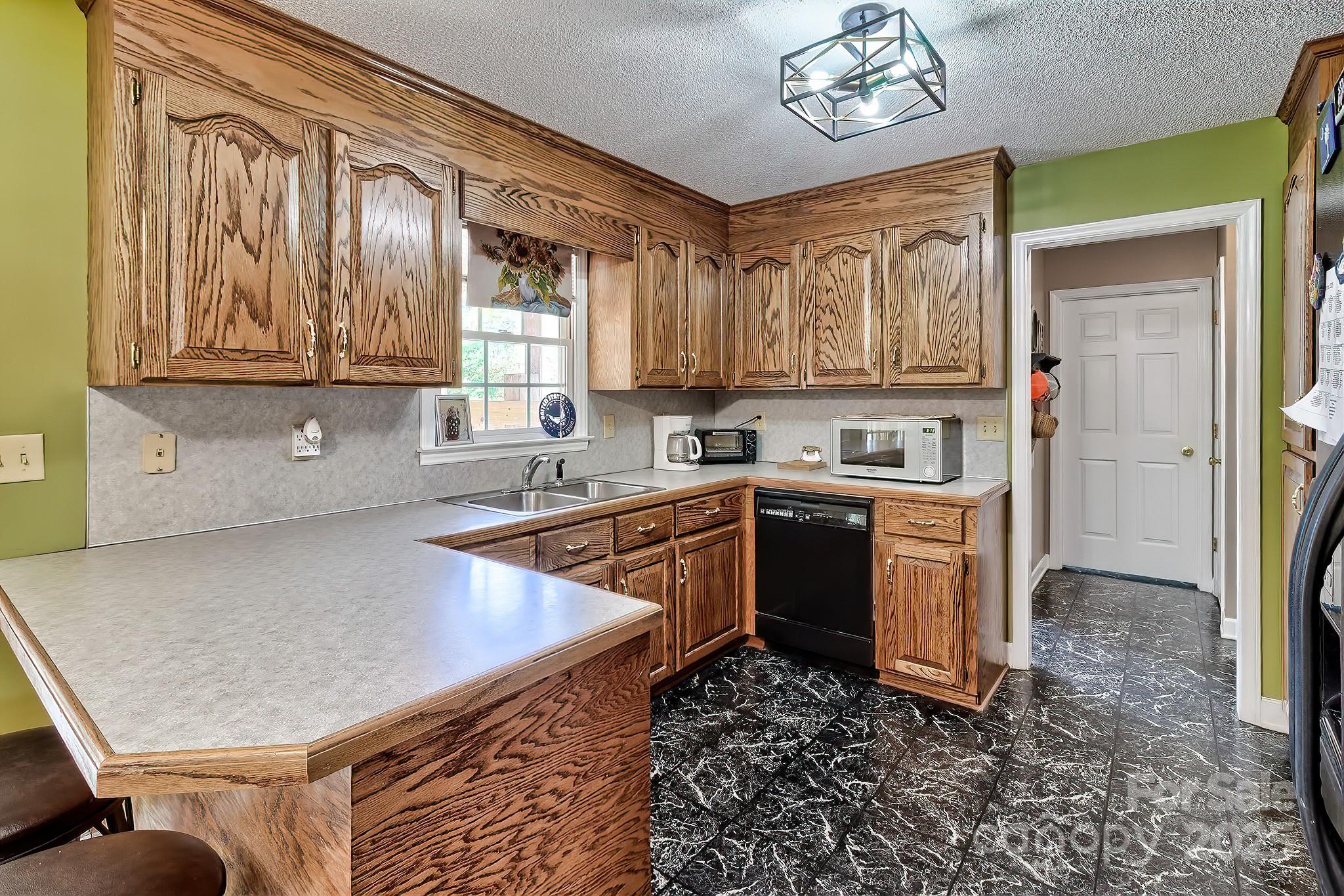176 Griffin Road Pageland, SC 29728 - Photo 28 of 46 a kitchen with stainless steel appliances granite countertop a sink dishwasher stove and refrigerator with wooden floor