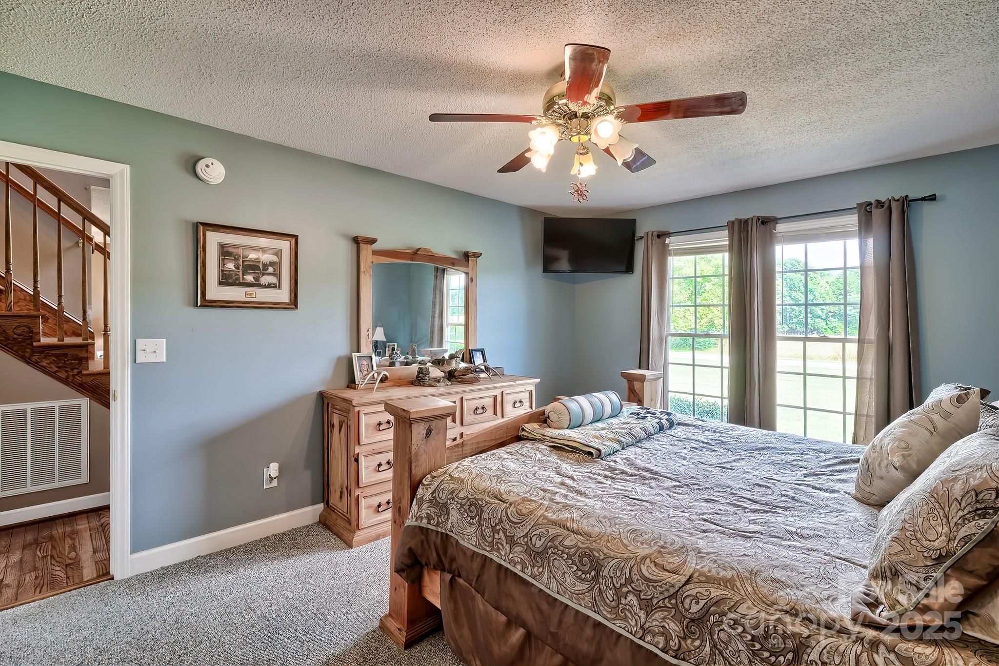 176 Griffin Road Pageland, SC 29728 - Photo 34 of 46 a bedroom with a large bed and a chandelier