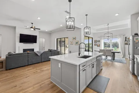 a kitchen with kitchen island granite countertop a sink appliances cabinets and a counter top space