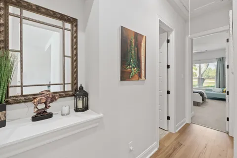 a dining room with wooden floor a chandelier a wooden table and chairs