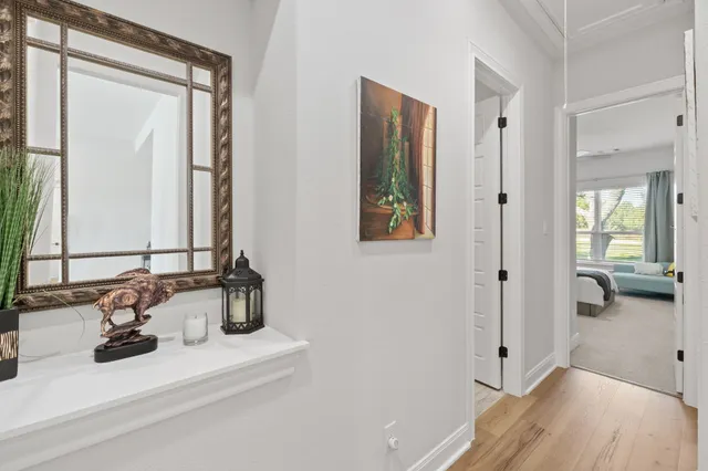 a dining room with wooden floor a chandelier a wooden table and chairs