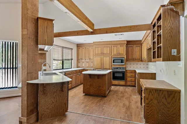 a large kitchen with stainless steel appliances granite countertop a sink and a refrigerator