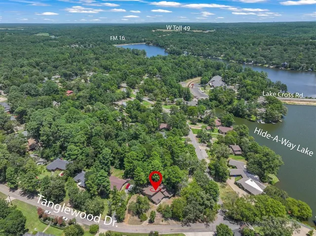 an aerial view of residential houses with outdoor space and trees