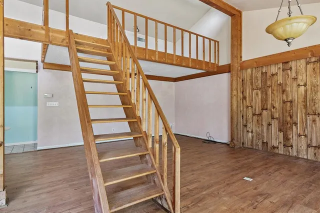 a view of staircase with wooden floor and white walls