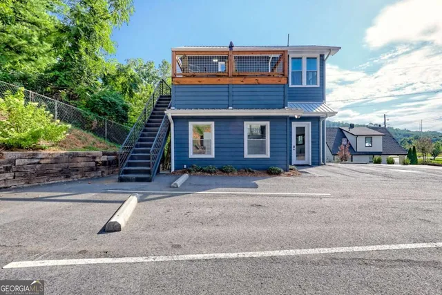 a bedroom with a bed a flat tv screen and a dresser
