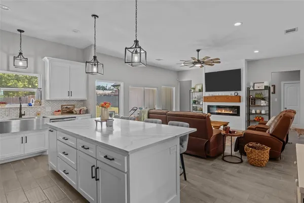 a kitchen with kitchen island granite countertop a sink stainless steel appliances and white cabinets