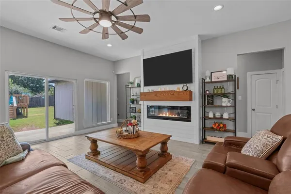 a living room with furniture a flat screen tv and a fireplace