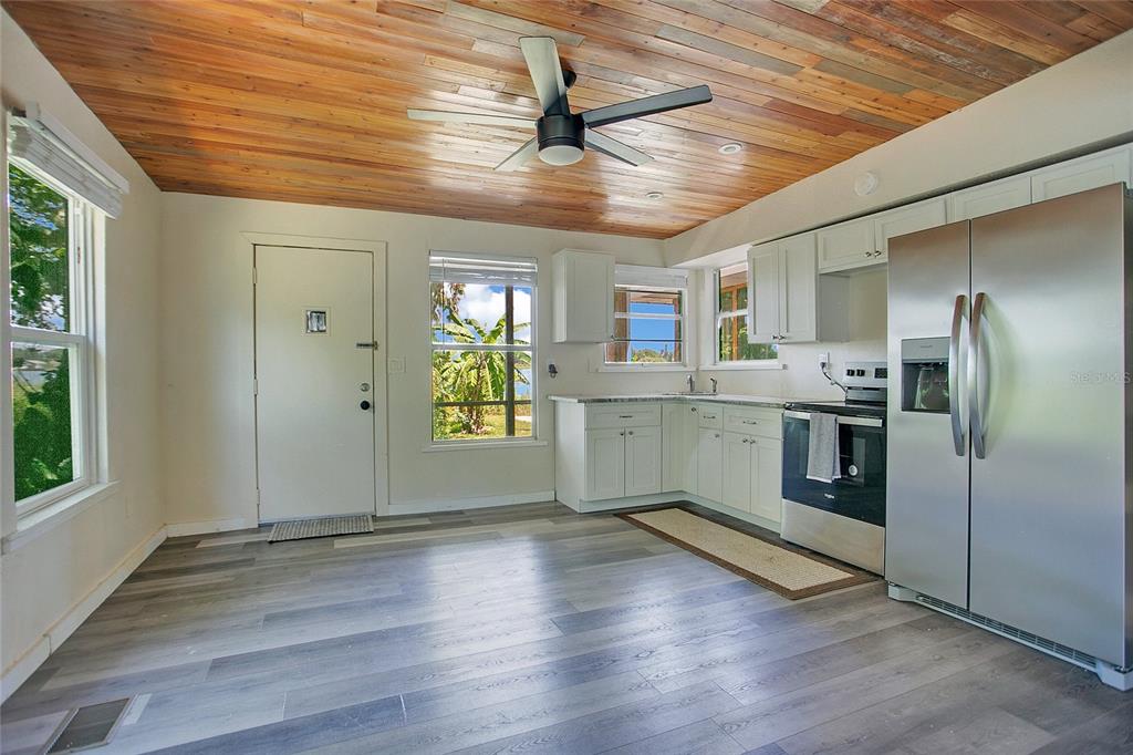 35 South Lake Fox Road Winter Haven, FL 33884 - Photo 13 of 43 a kitchen with stainless steel appliances granite countertop a refrigerator a sink dishwasher a stove and white countertops with wooden floor