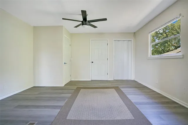 a view of a livingroom with a ceiling fan & window