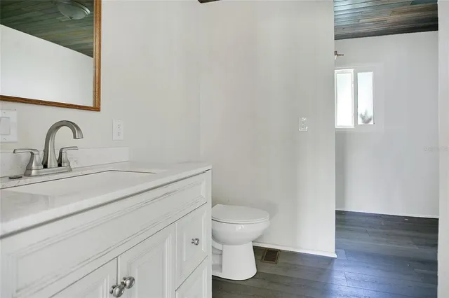 a bathroom with a toilet a sink and mirror