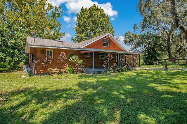 a front view of house with yard barbeque and outdoor seating