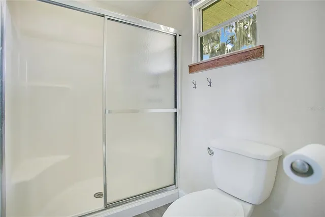 a white toilet sitting next to a shower