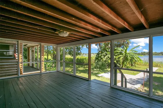 a porch with wooden floors in front of a house