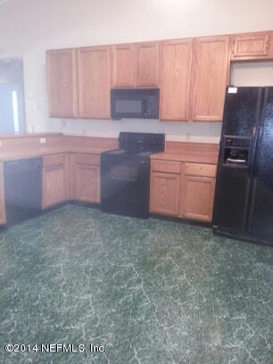 3493 White Wing Road Orange Park, FL 32073 - Photo 5 of 27 a kitchen with a refrigerator stove and cabinets