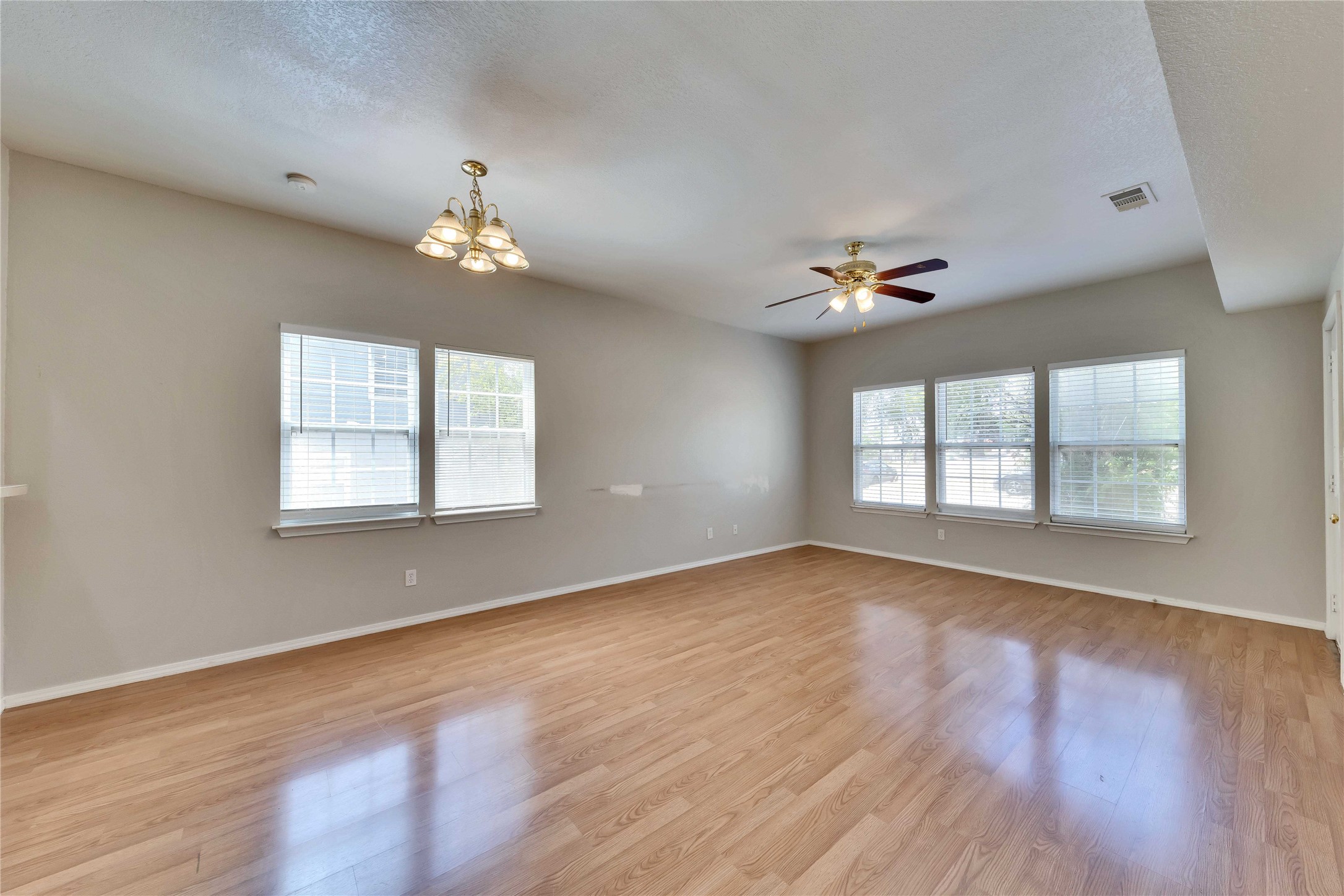 2201 East 18th Street, Unit B Austin, TX 78702 - Photo 2 of 25 Natural light fills this generous living space, showcasing wood-look flooring and a versatile ceiling fan.