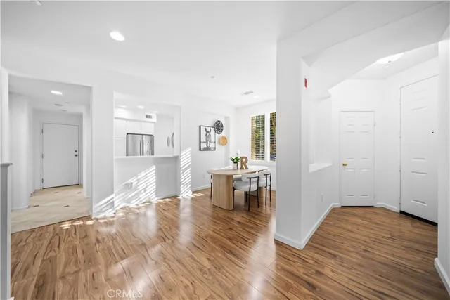 an empty room with wooden floor and a bathroom