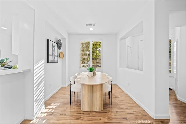 a dining room with wooden floor and window