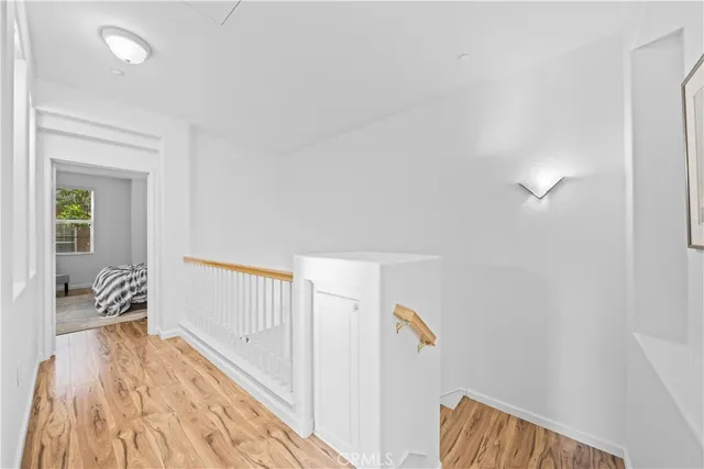 a view of a bedroom with wooden floor and furniture