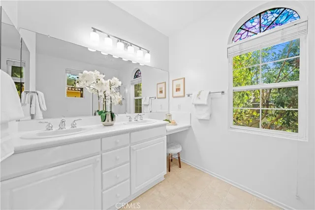 a spacious bathroom with a sink a large mirror and a window