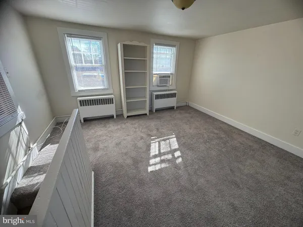 an empty room with windows and cabinet