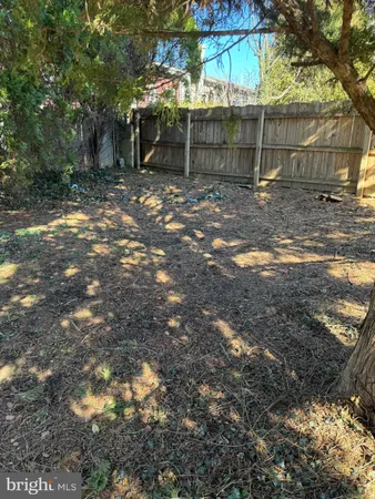 a backyard of a house with large trees and a barn