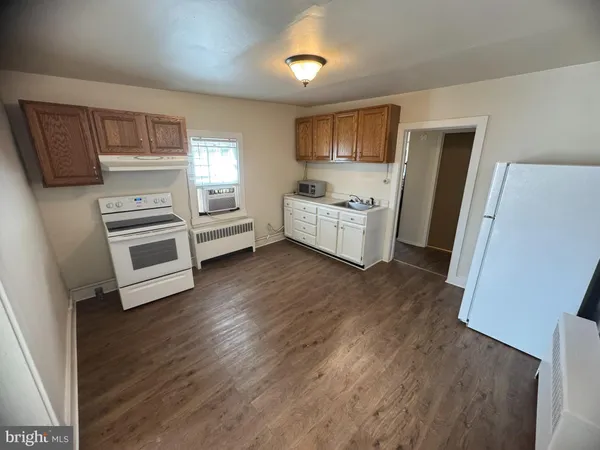 a kitchen with a refrigerator and a stove top oven