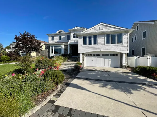 a front view of a house with a yard and lake view
