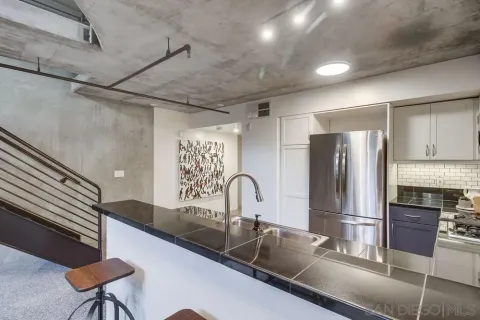 a kitchen with stainless steel appliances granite countertop a sink and a refrigerator