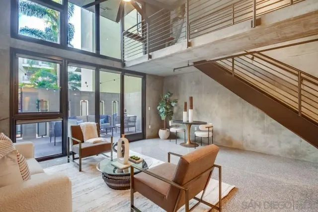a living room with furniture and floor to ceiling windows