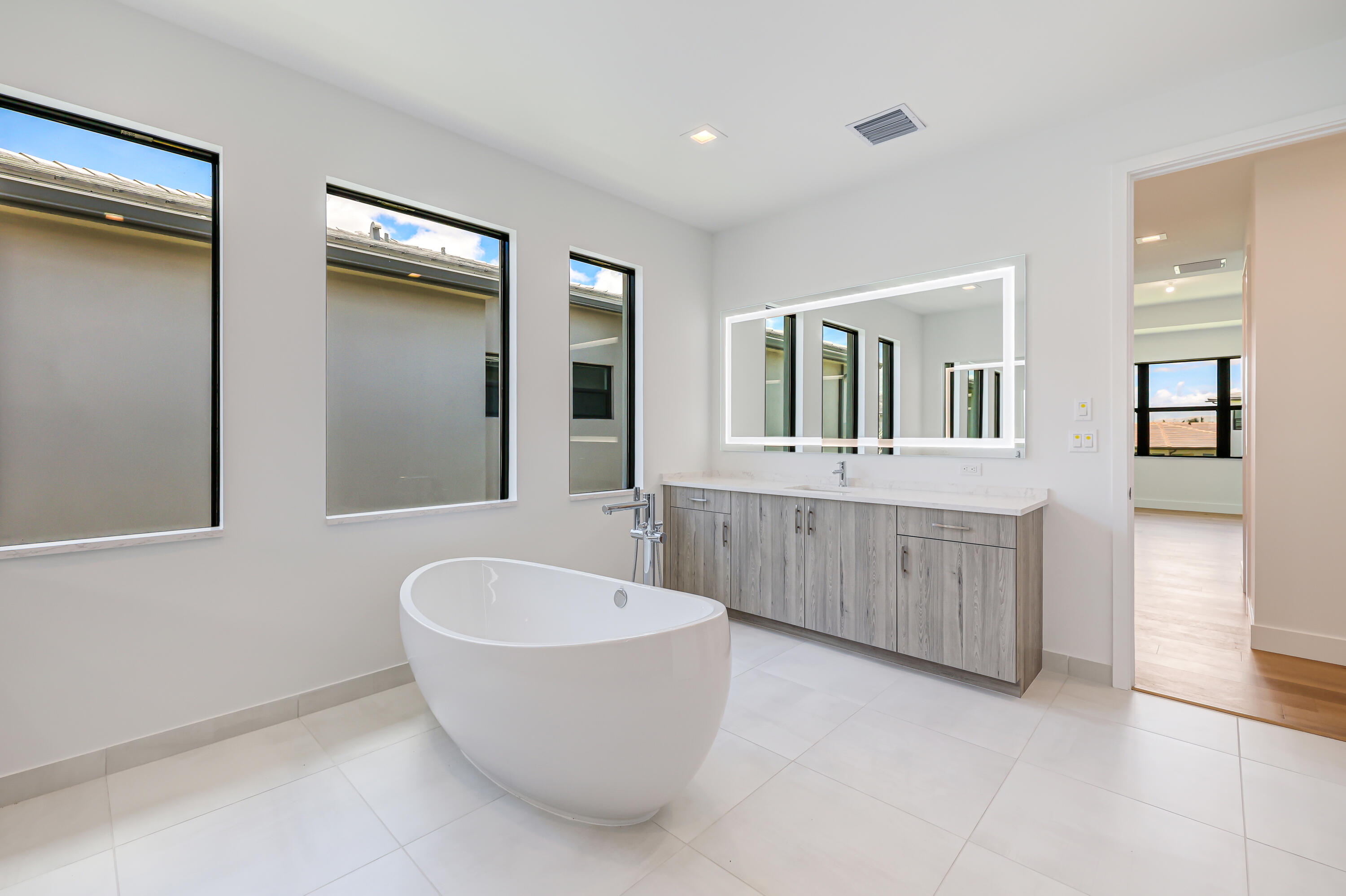 9451 Riverside Pk Drive Boca Raton, FL 33434 - Photo 32 of 71 a spacious bathroom with a double vanity sink tub and mirror