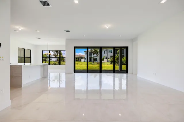 a large white kitchen with kitchen island a sink a counter and a refrigerator