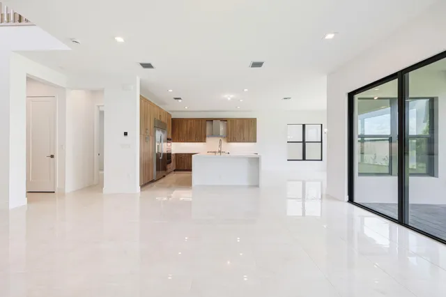 a kitchen with stainless steel appliances kitchen island granite countertop a refrigerator and cabinets