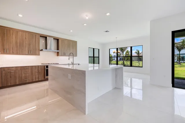 a large kitchen with stainless steel appliances granite countertop a lot of counter space and wooden floor