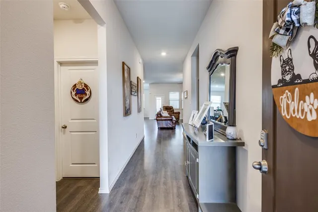 a view of a hallway with wooden floor and windows