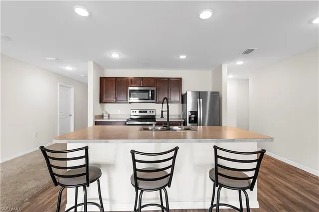 a kitchen with refrigerator and chairs