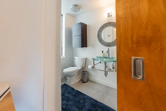 a bathroom with a toilet sink and mirror
