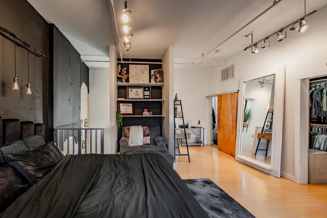 a view of a hallway with wooden floor and furniture