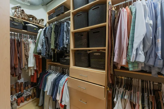 a view of walk in closet with clothes and shoes