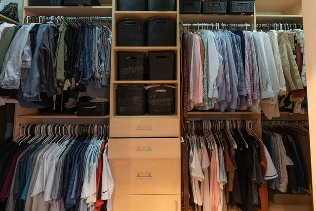 a view of walk in closet with clothes and shoes