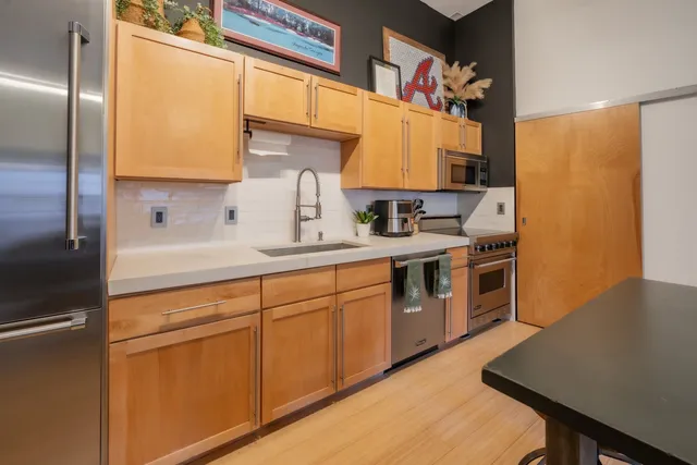 a kitchen with stainless steel appliances granite countertop a sink stove and refrigerator