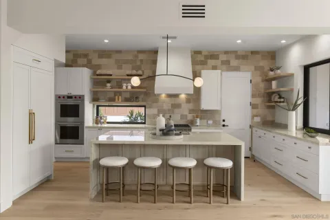 a kitchen with stainless steel appliances granite countertop a sink a stove and a wooden cabinets