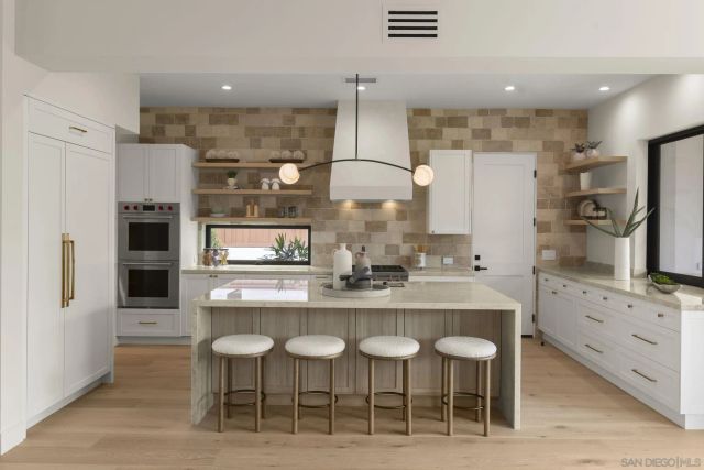 a kitchen with stainless steel appliances granite countertop a sink a stove and a wooden cabinets