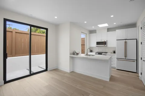a kitchen with stainless steel appliances a refrigerator sink and microwave