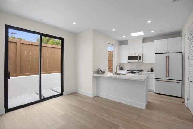 a kitchen with stainless steel appliances a refrigerator sink and microwave