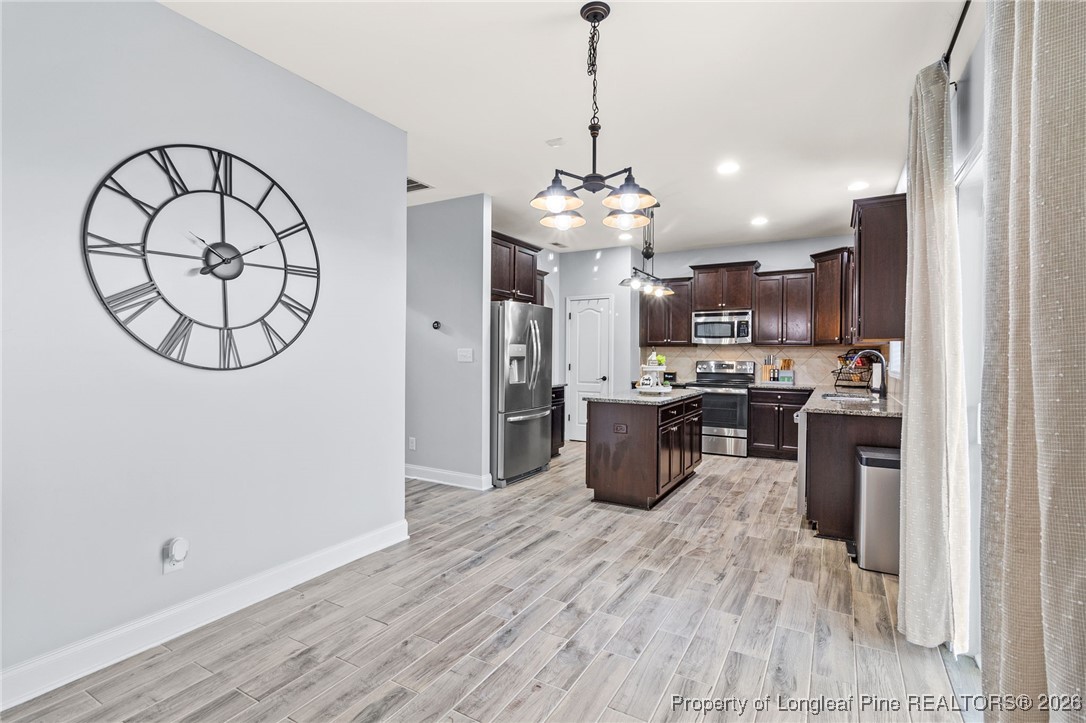 121 Colonist Place Cameron, NC 28326 - Photo 11 of 46 a view of a kitchen center island wooden floor and stainless steel appliances