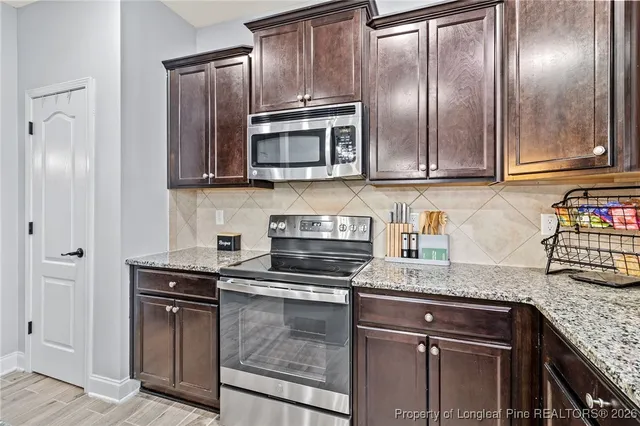 a kitchen with granite countertop stainless steel appliances and wooden cabinets
